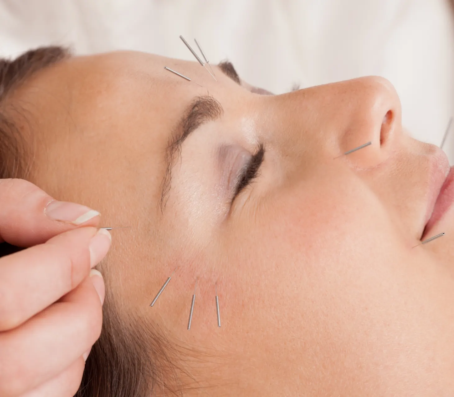 Jade gua sha tools and rose quartz crystals on cream silk